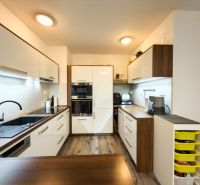 A kitchen in a 3-room apartment with a wooden decor and modern appliances.