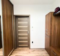 Entrance hall in a 3-room apartment with wooden decor furniture and storage space.