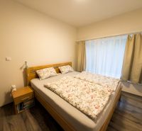 A bedroom in a 3-room apartment with a bed, curtains, and a floor with a wooden decor.