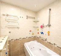 Bathroom in a 4-room apartment with a bathtub and ceramic tiles on the walls.
