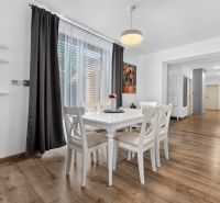 Dining table with chairs on a wooden floor in a family house.