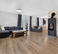 A living room of a family house with a fireplace and a wooden decor floor.