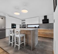 A kitchen in a family house with white cabinets and a kitchen island.