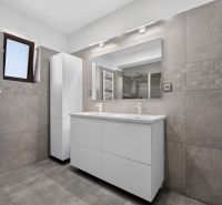A bathroom in a family house with a double sink and modern tiles.