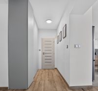 A hallway in a family house with a wooden decor floor and modern lighting.