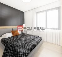 Bedroom in a 2-room apartment with wood-patterned flooring and a large window.
