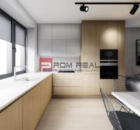 A kitchen in a 2-room apartment with a wooden decor floor, light cabinets, and a large window.