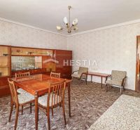 The interior of a family house with 20th-century furniture and a patterned carpet.