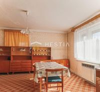 Interior of a family house with a dining table, older furniture, and a carpet.