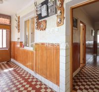 A hallway in a family house with checkered tiles and wooden wall paneling.