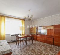 Living room in a family house with wooden furniture and a patterned carpet.