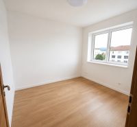 A bright room in a 2-room apartment with white walls and a wooden decor floor.