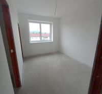 A room in a 2-room apartment with finished white walls and a large window.