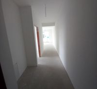 A hallway in a 2-room apartment with a bright interior and an empty floor without decor.