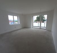 In the bright room of the 2-room apartment, there are large windows and balcony doors.