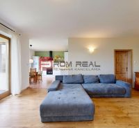 Living room in a family house with a corner sofa and a floor with a wooden decor.