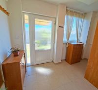 In a family house, a bright hallway with a chest of drawers, a mirror, and a plant.