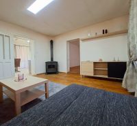Living room in a family house with a wood-burning stove and a floor with a wooden decor.