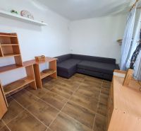 Living room with a corner sofa, wooden furniture, and a floor with a wood decor.