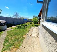 A garden at a family house in Jasová with a lawn and a well.