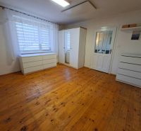 A room in a family house with white furniture and a wooden decor floor.