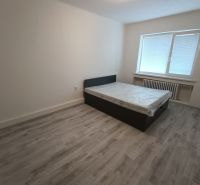 A bedroom in a 2-room apartment with a bed and a floor with a wooden decor.