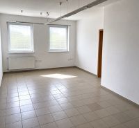 Spacious office with tiles, white walls, and two windows.