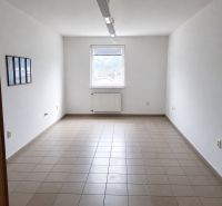Offices with simple walls and tiled floors, central window, minimalist furnishings.