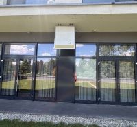 Commercial premises on Nové záhrady I, Bratislava - Ružinov, with a glass entrance and outdoor greenery.