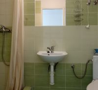 Bathrooms in hotels and guesthouses with a sink, shower, and toilet, light green tiles.
