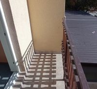 A balcony with tiles and wooden railing in hotels and guesthouses in Patince.