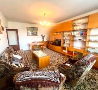 Living room in a family house with classic furniture and a patterned carpet.
