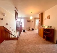 Interior of a family house with wooden paneling and carpet on the floor.