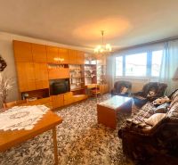 Living room with a carpet, sofa, and wall unit in a family house.