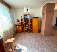 Living area in a family house with a wooden decor floor and a display cabinet.