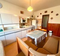 A kitchen in a family house with seating, a kitchen unit, and wall decorations.