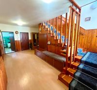 Entrance hall with wooden stairs and a floor with a wooden decor in a family house.