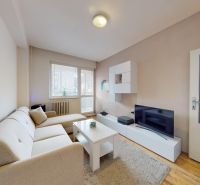 Living room of a two-room apartment on K výstavisku street with a comfortable sofa and a television.