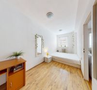A bright bedroom in a 2-room apartment, with a bed and wooden flooring on K výstavisku street.