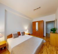 Bedroom with a wardrobe and two bedside tables in a 2-room apartment on K výstavisku street.