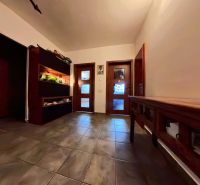 A hallway in a 4-room apartment with a shelf and tiled floor.