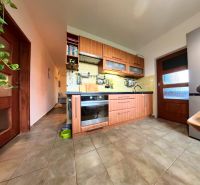 A kitchen in a 4-room apartment with tiles and a wooden decor kitchen unit.