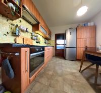A kitchen in a 4-room apartment with a wooden kitchen unit and modern appliances.