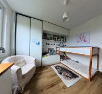 Children's room with a built-in wardrobe, bed, and floor with wooden decor in a 4-room apartment.