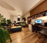 Living room with a home office in a 4-room apartment with a wooden decor floor.