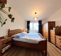 A bedroom in a 4-room apartment with wooden furniture and a wooden decor floor.