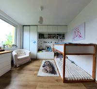A room in a 4-room apartment with a wooden decor floor, a bed, and wardrobes.