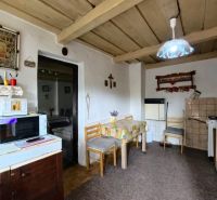 A kitchen in a family house with a wooden ceiling, decorations, and a microwave oven.