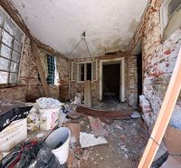 The interior of a family house with unplastered brick walls and construction mess.