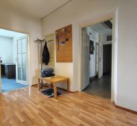 Offices with wood-patterned flooring, a coat rack, a table, and adjacent rooms.